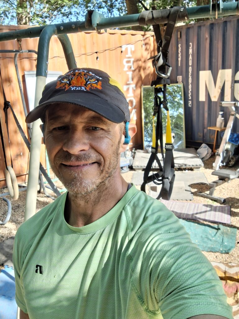 Man in outdoor home gym with TRX straps and training equipment